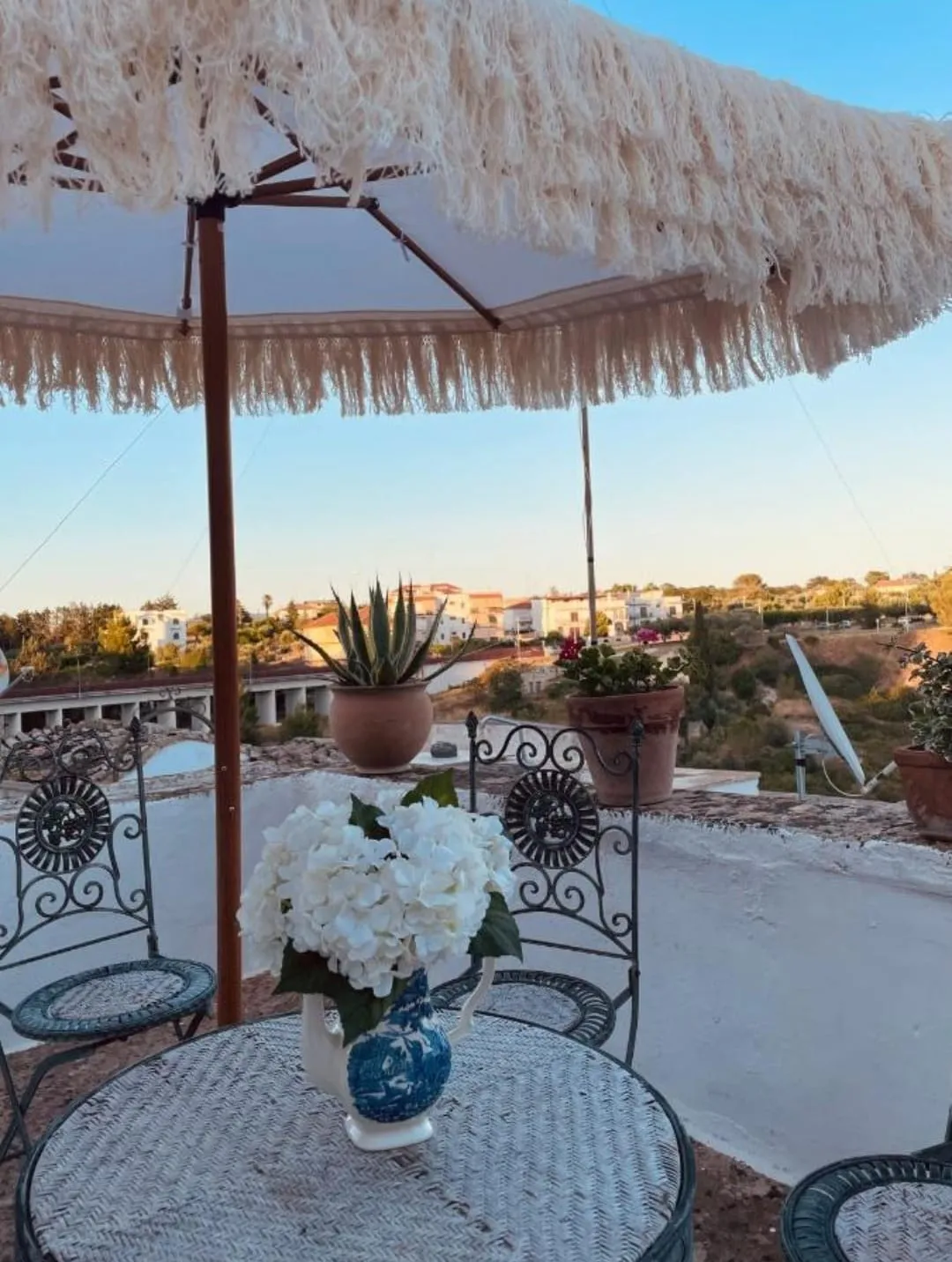 Il Bacio — terrazzino con tavolino in ferro battuto e ortensie al tramonto