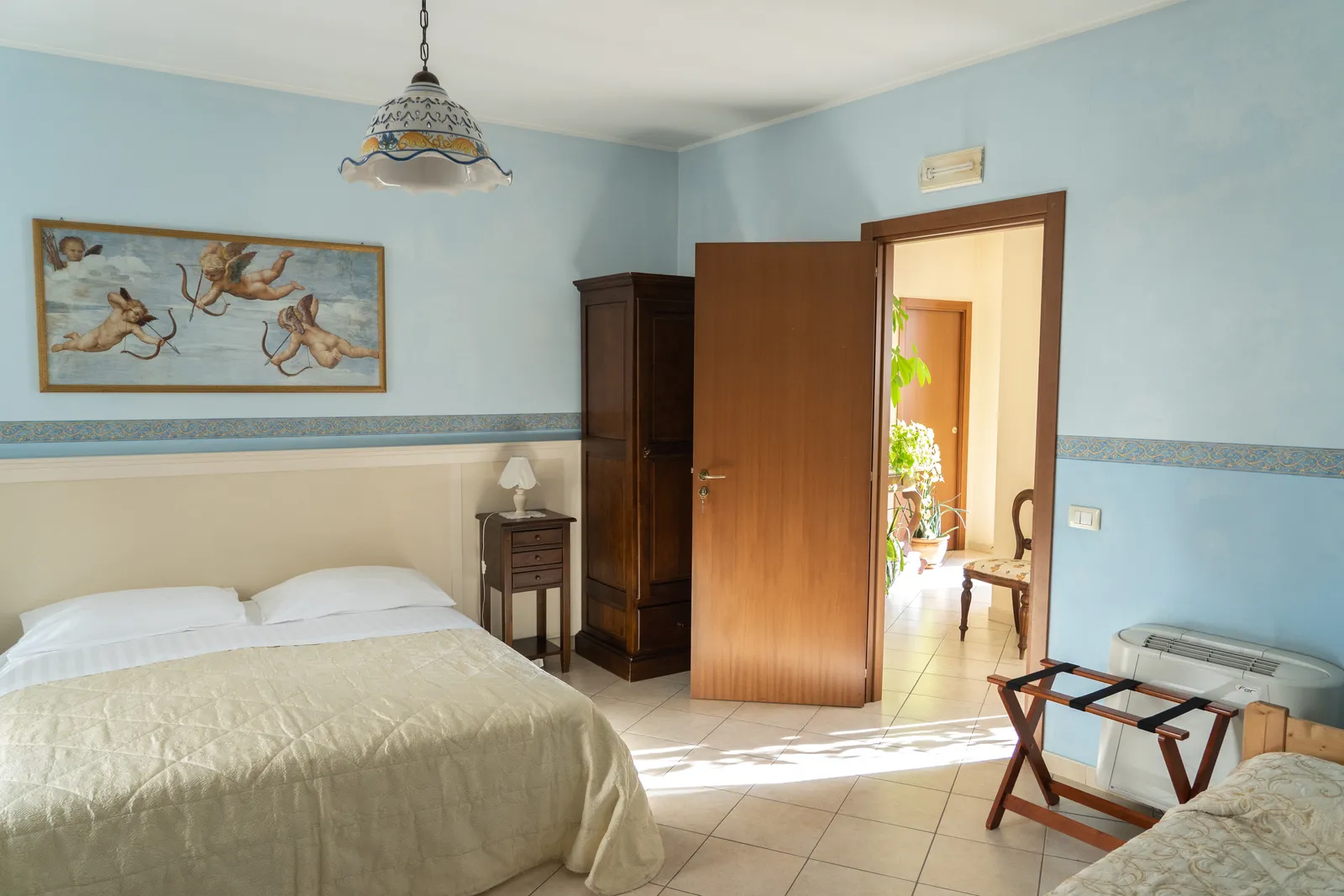 Camera del B&B Iris con pareti azzurre e dettagli in maiolica